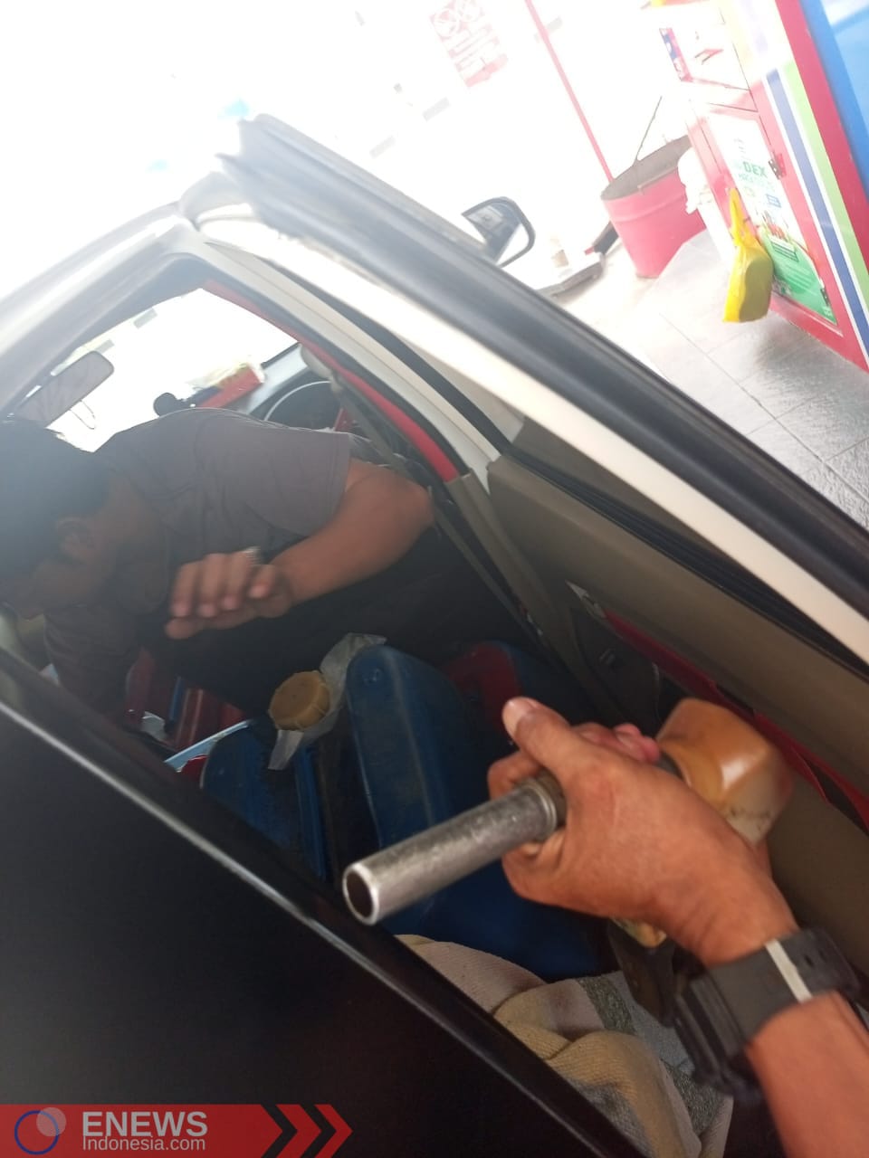 Foto: Mobil Avanza putih saat melakukan pengisian solar bersubsidi dalam jeriken yang diletakkan di dalam mobil. (Dok. ENews)