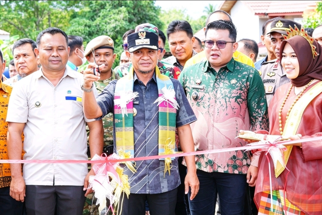 Ketgam: Bupati Bone Andi Asman Sulaiman saat meelakukan oengguntingan pita dalam peresmian jalan kabupaten di Desa Selli. (Dok. ENews)