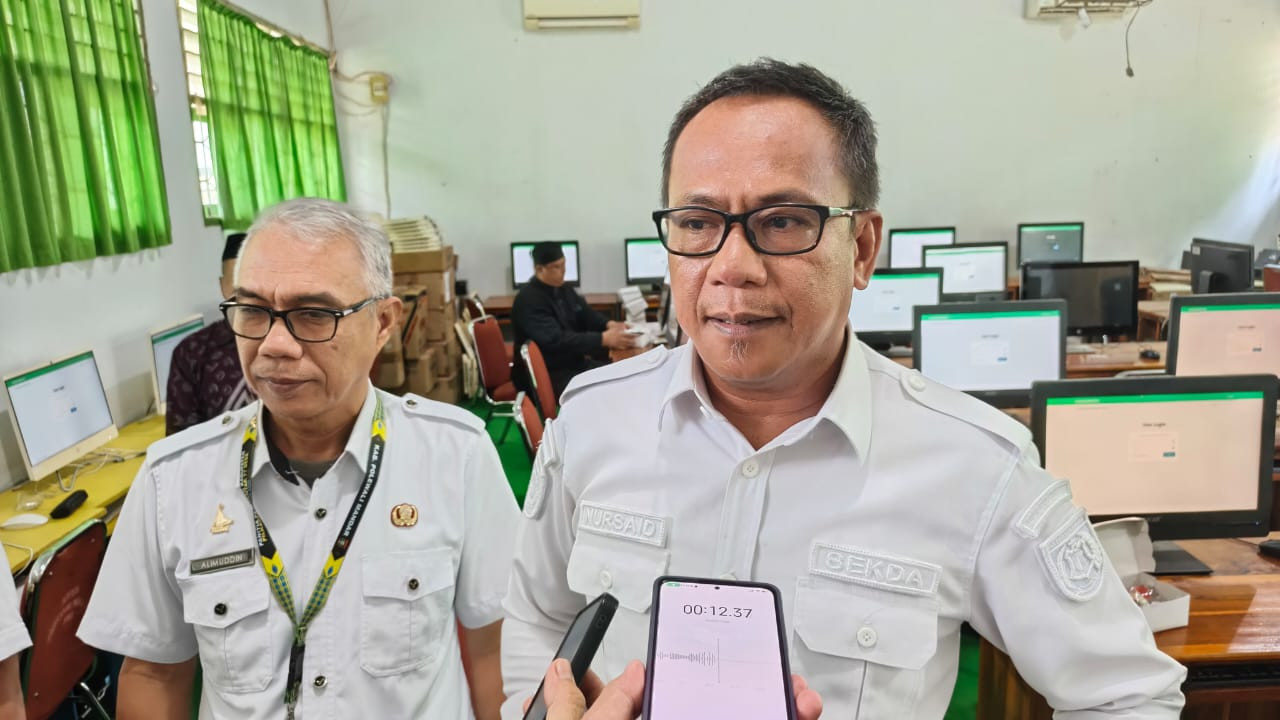 Foto: Sekda Polman, Nursaid Mustafa didampingi Kepala Dinas PMD Alimuddin saat melakukan pemantauan tes CAT Calon Kepala Desa di SMAN 1 Polewali. (Dok. HW)